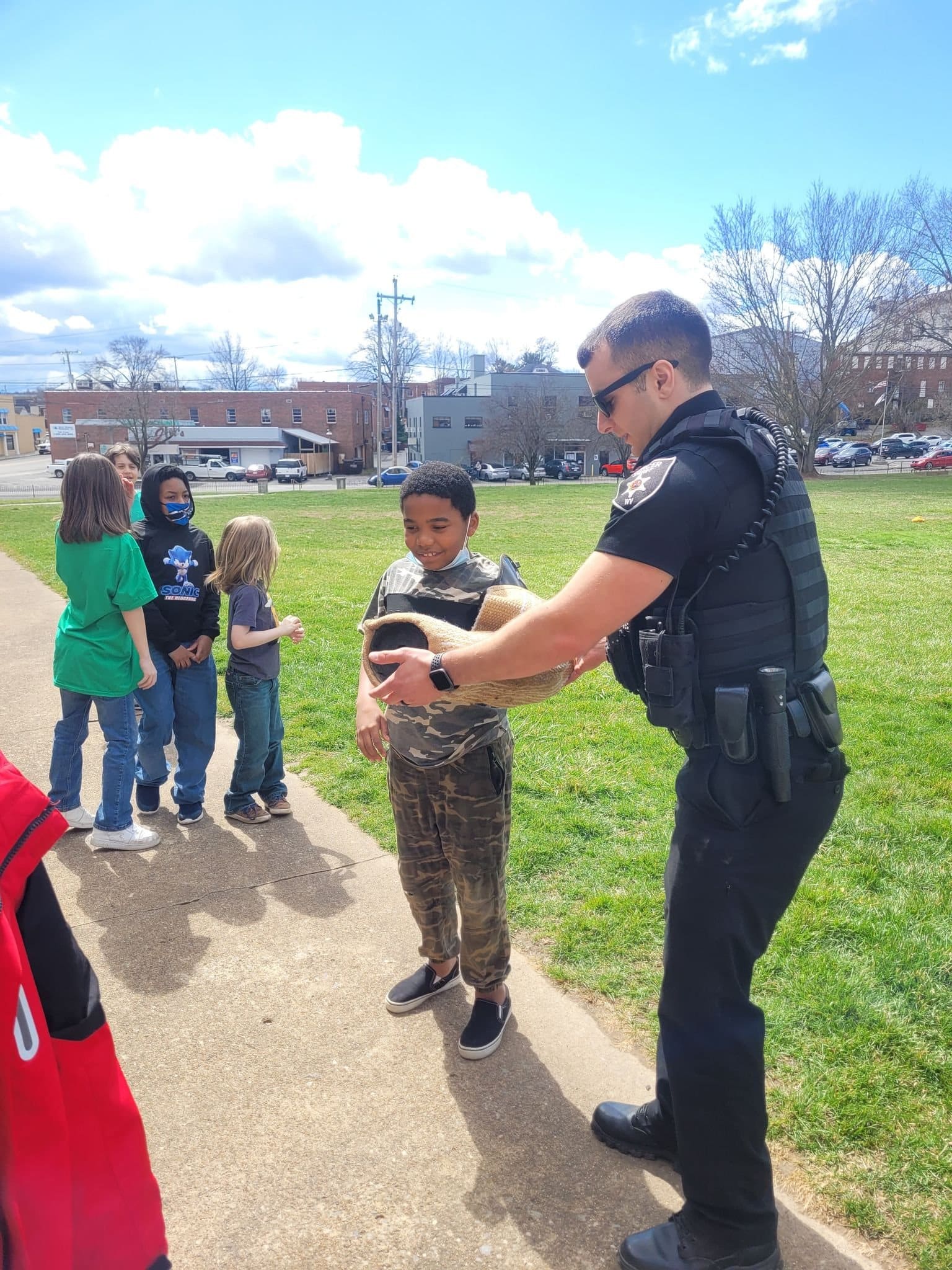 A department deputy interacting with children at an outreach event at a local school.